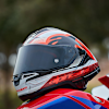 alpinestars_racing-motorcycle-helmet_supertech-r10_team-gloss-black-carbon-red-white_lifestyle1.jpg